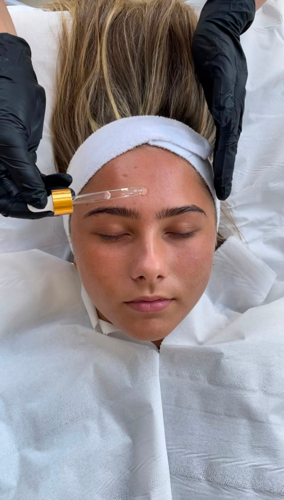 Skincare serum being applied to the forehead during a professional facial